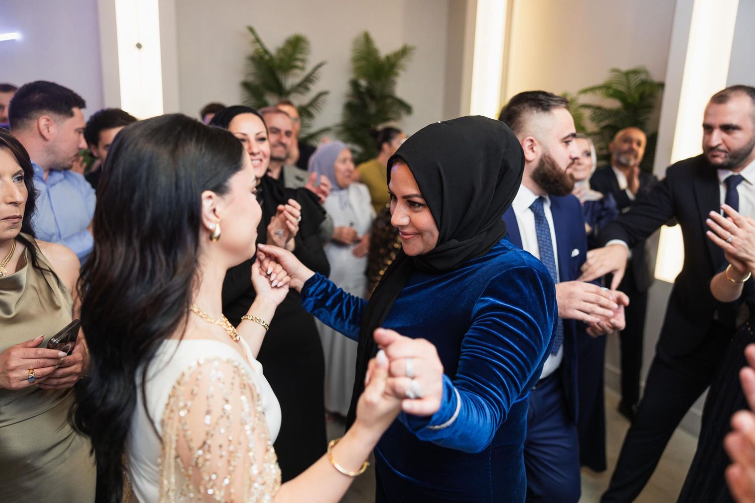 Guests dancing and celebrating at a wedding reception with a mix of traditional and modern attire.