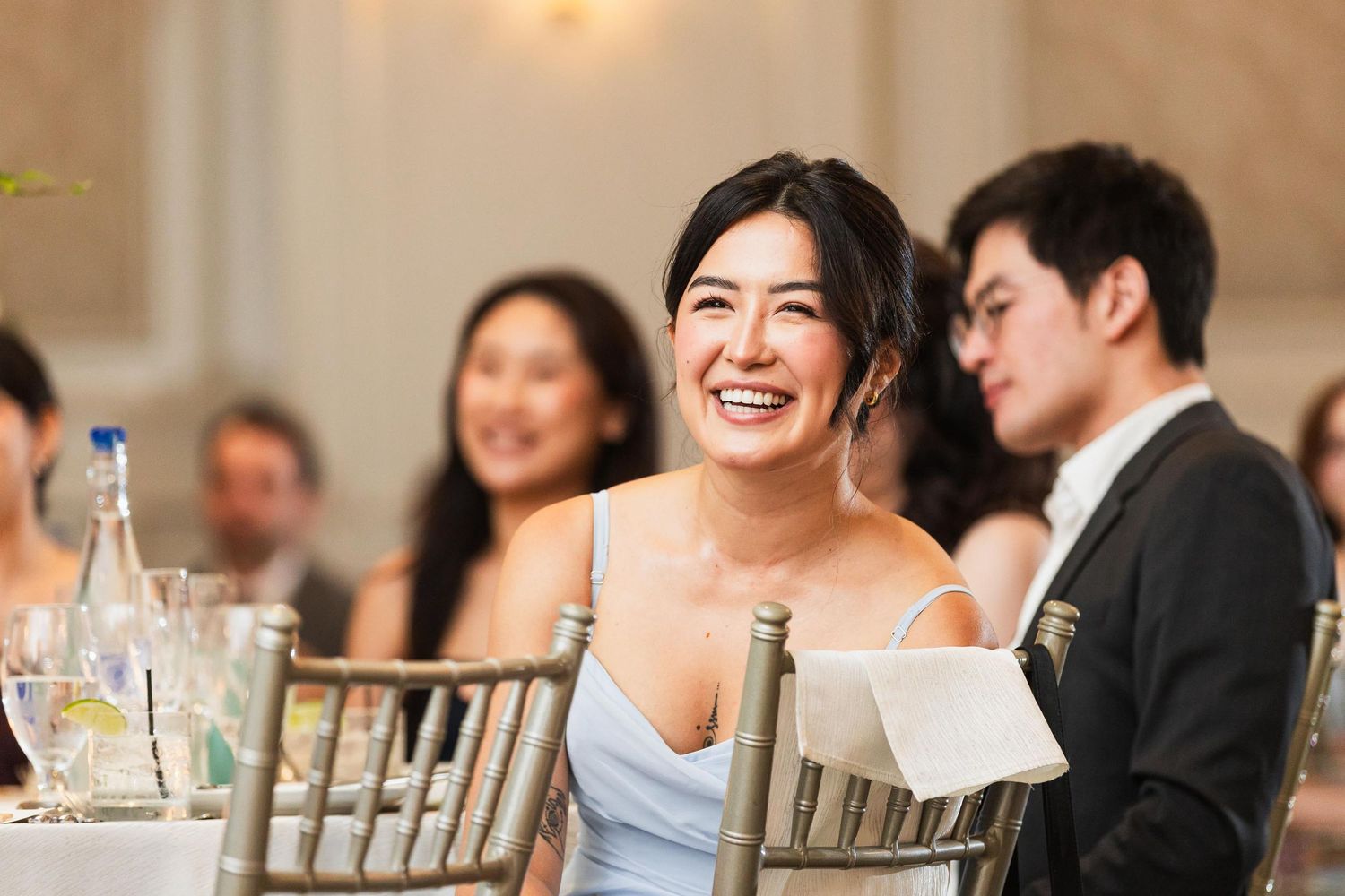 Wedding guest laughing joyfully during reception dinner.