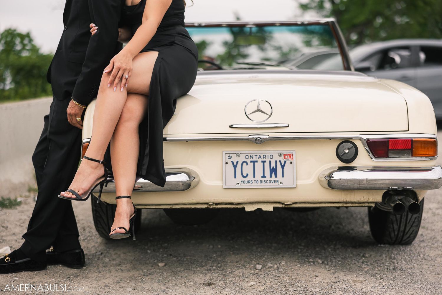 Close-up view of legs and classic Mercedes-Benz trunk with New York license plate.