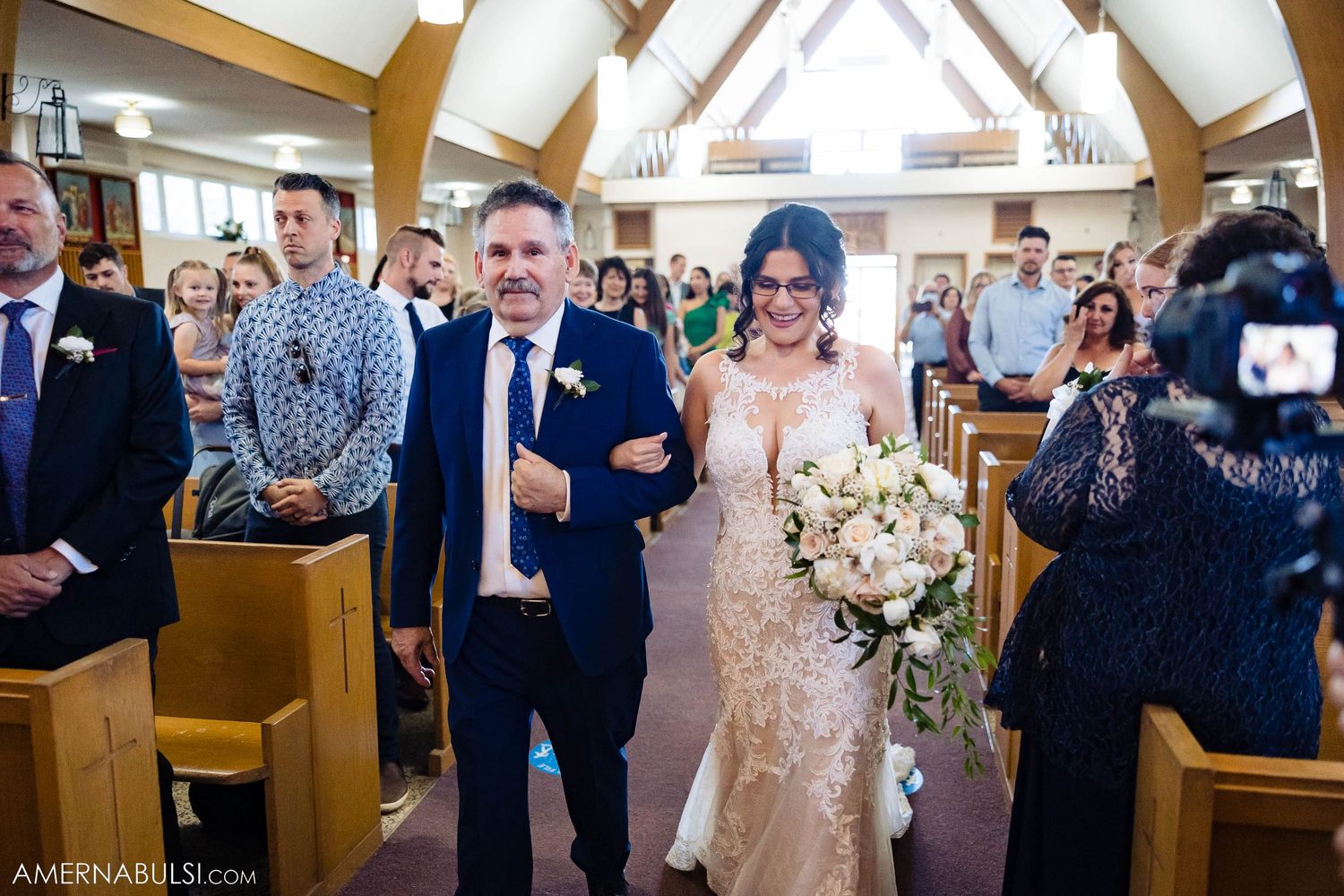 Emotional embrace between groom and wedding guest during church ceremony.