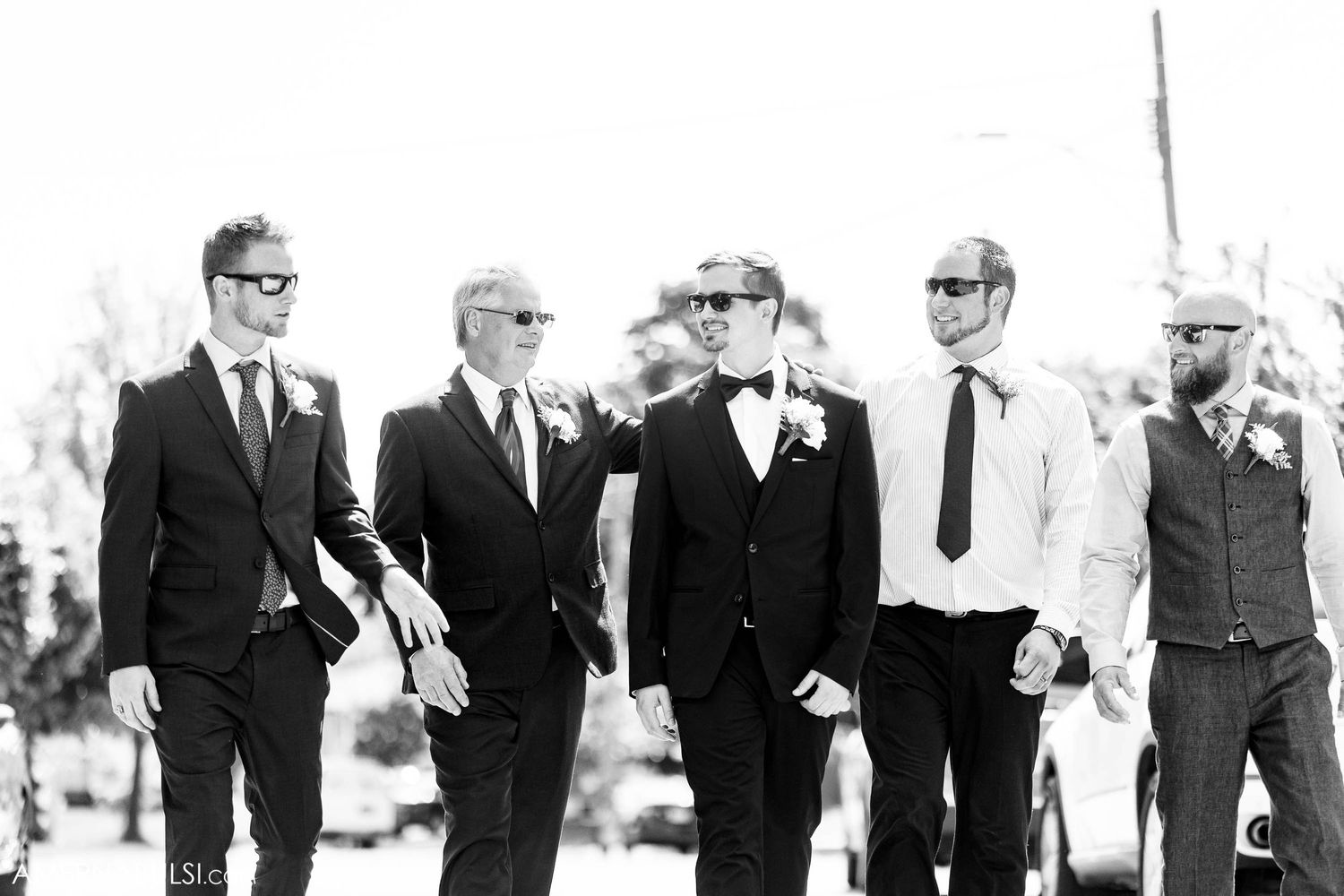 Black and white portrait of groomsmen in formal attire standing together.