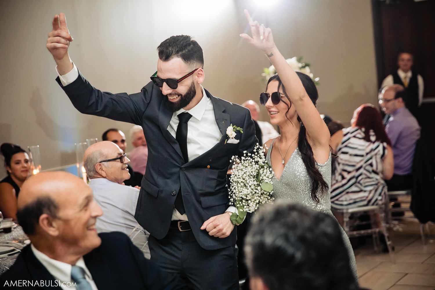 Wedding reception guests dancing and celebrating on dance floor.