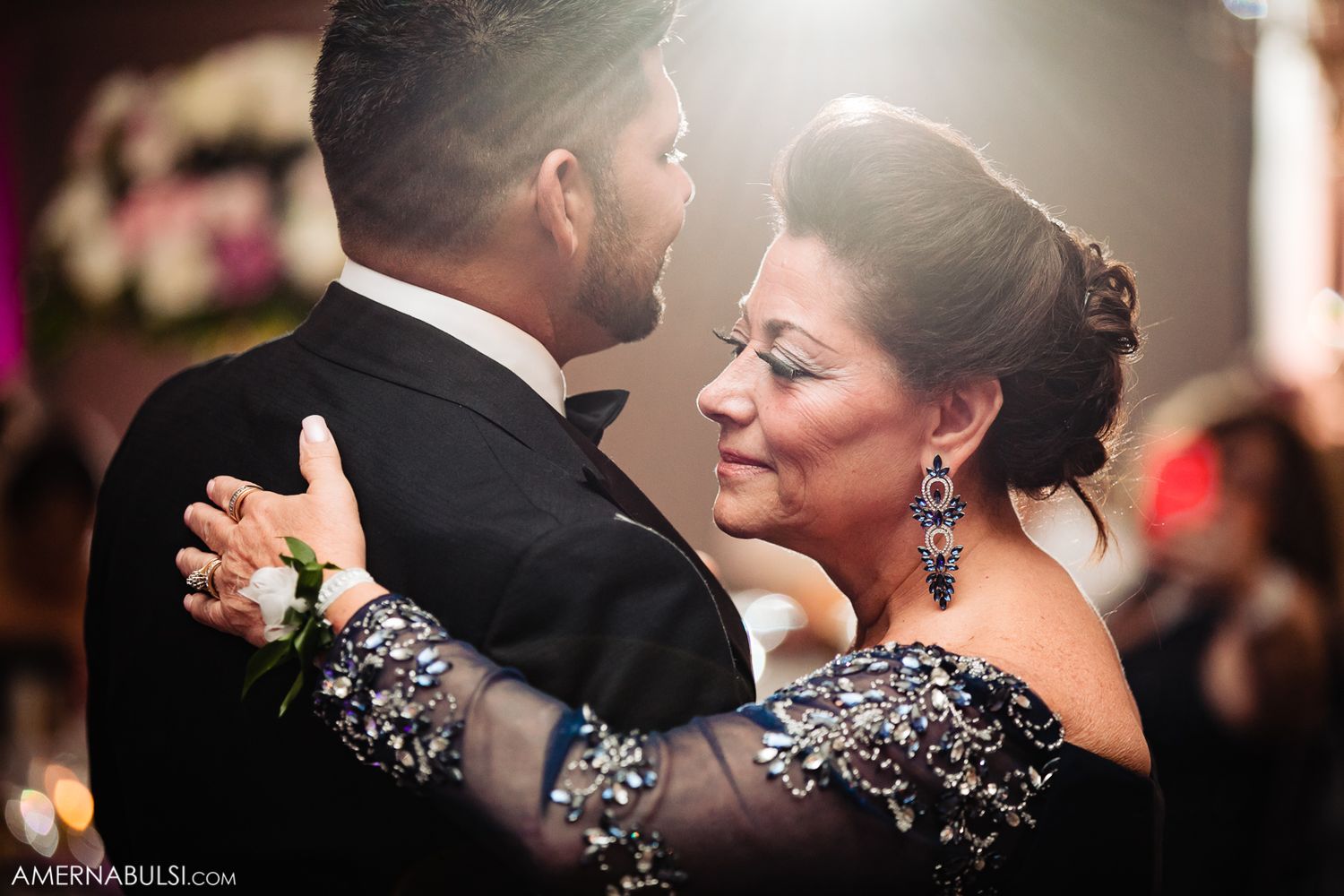 Elegant wedding reception dance floor scene with soft lighting and formal attire.