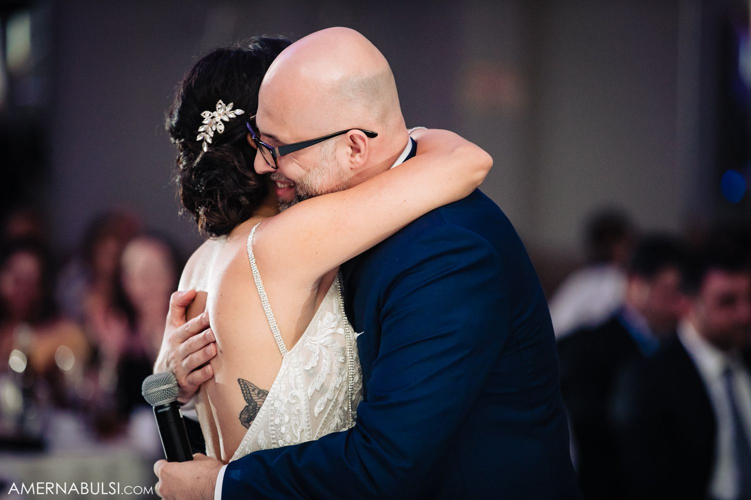 A tender embrace between newlyweds during their first dance at an elegant wedding reception.