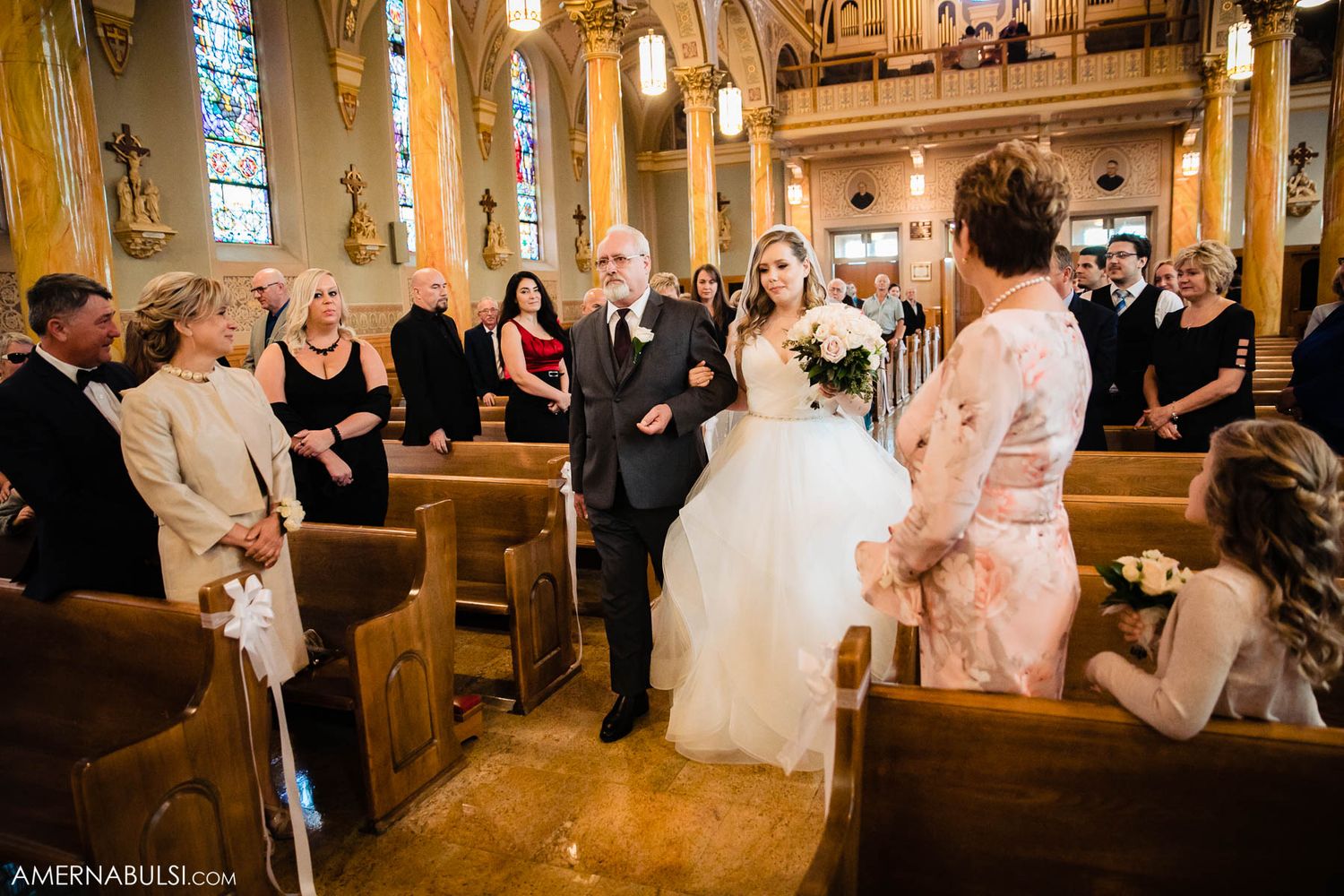 Wedding celebration in a rustic wooden church with stained glass windows and warm lighting.