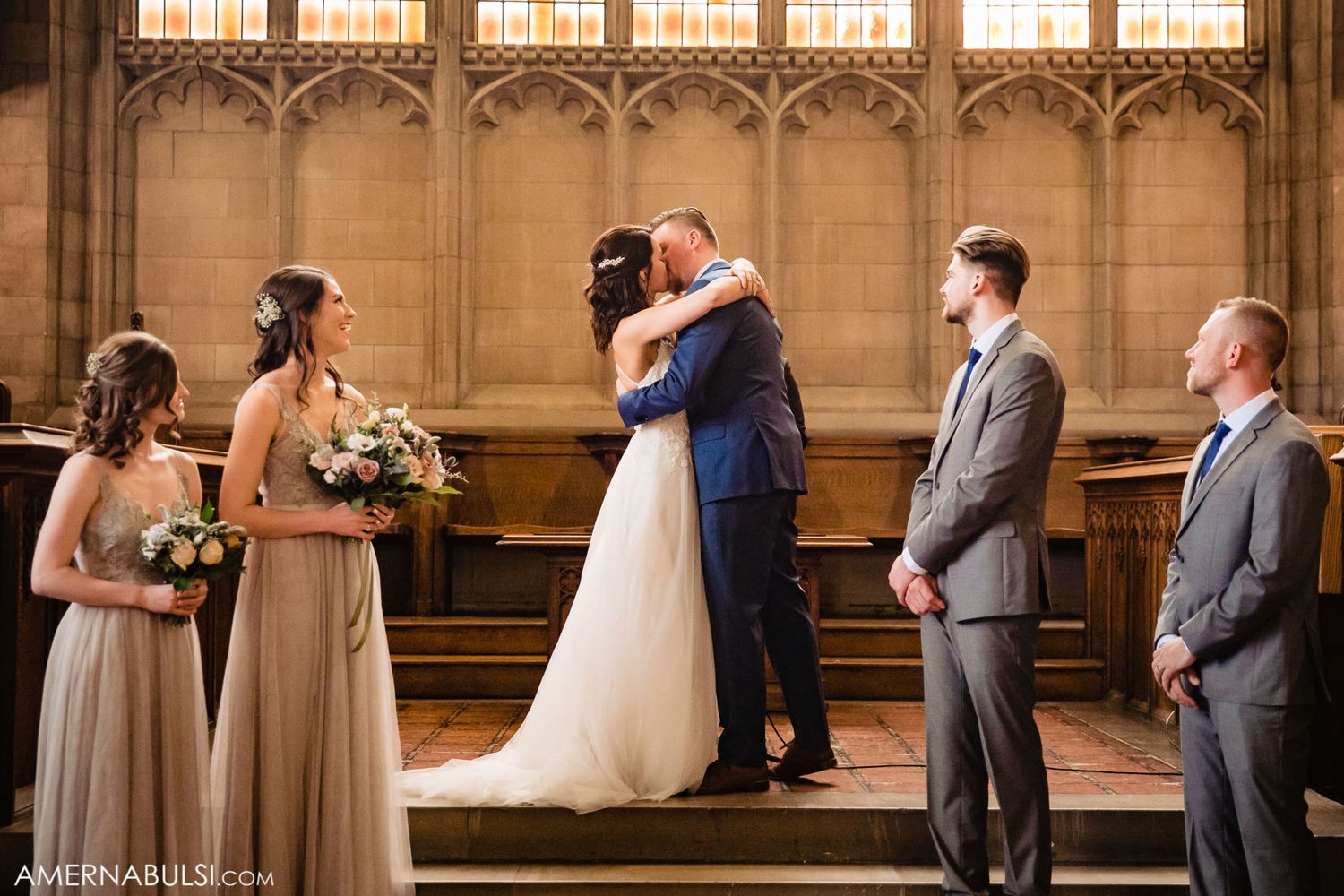 Wedding ceremony in historic venue with tall windows and architectural details.