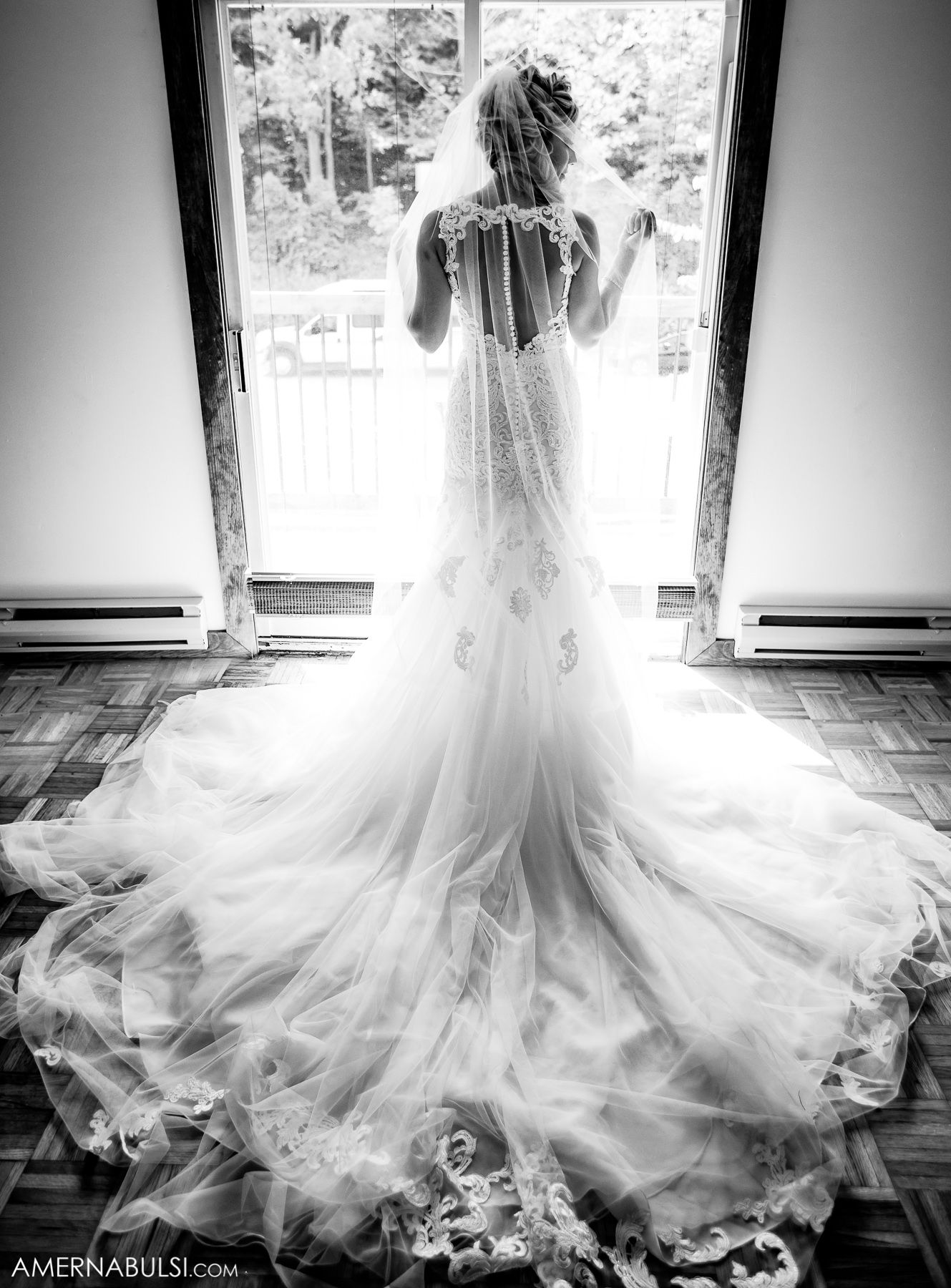 A flowing white wedding dress with a dramatic train captured in a series of black and white silhouettes against a bright window.