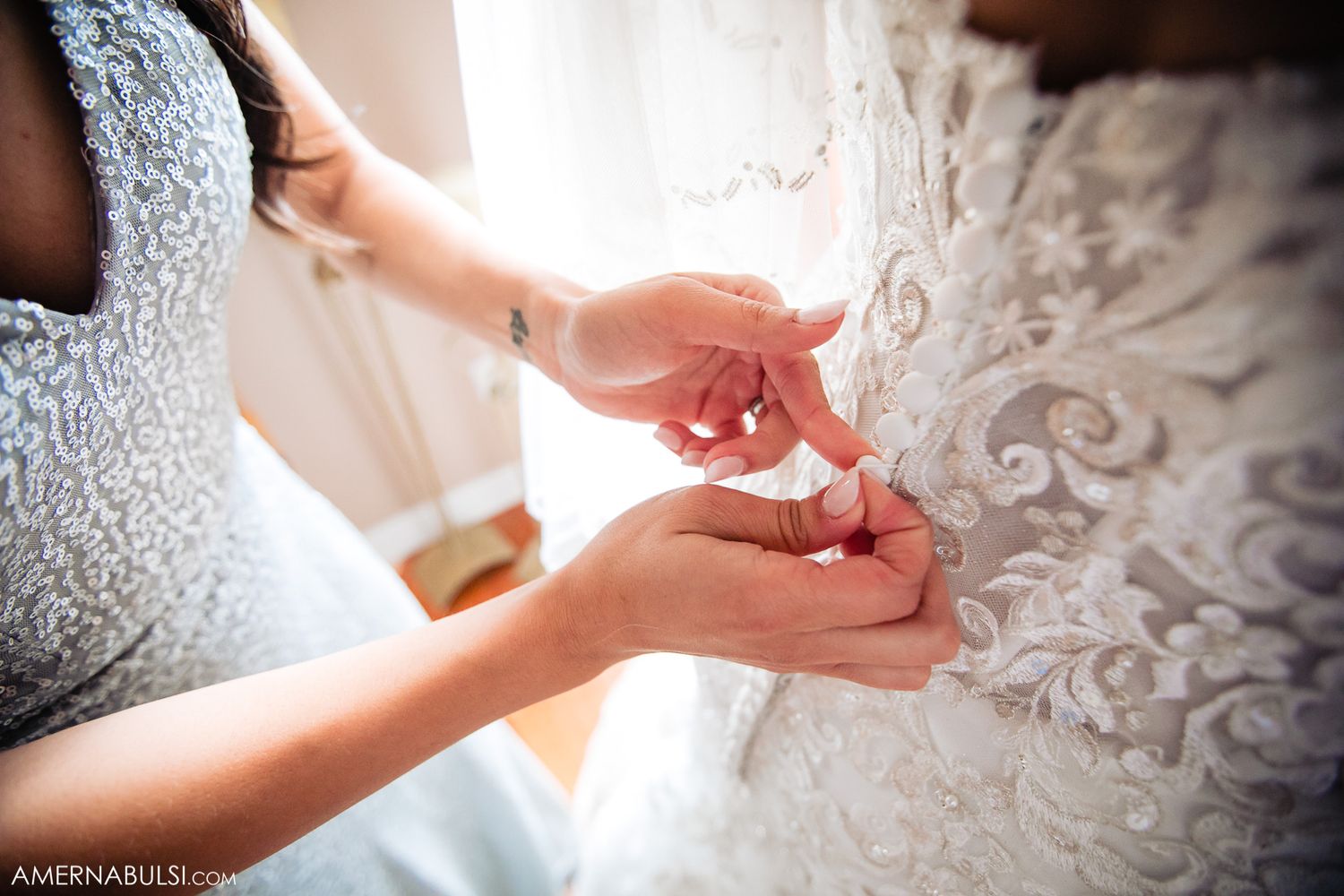 Close-up details of delicate lace and beading on an elegant white wedding dress.