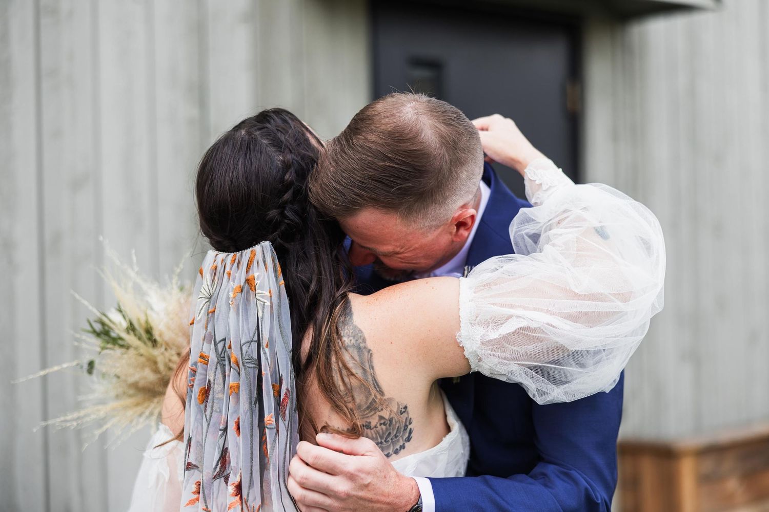 Intimate wedding moment captured as couple embraces outdoors.