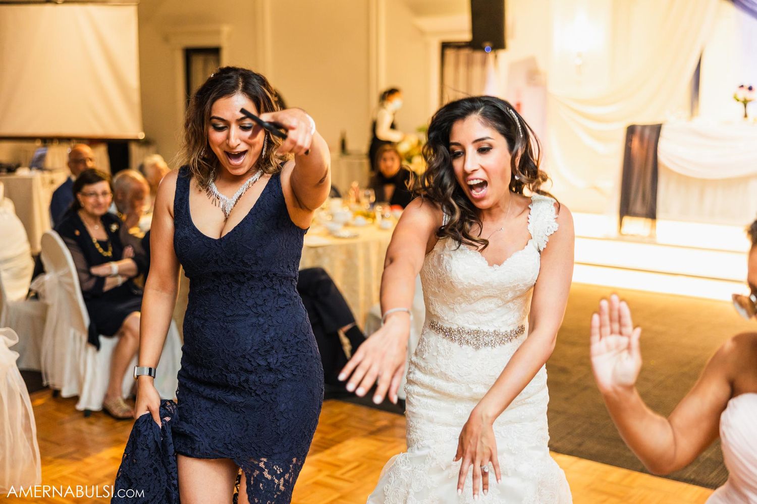 Wedding guests dancing together at an elegant indoor reception.