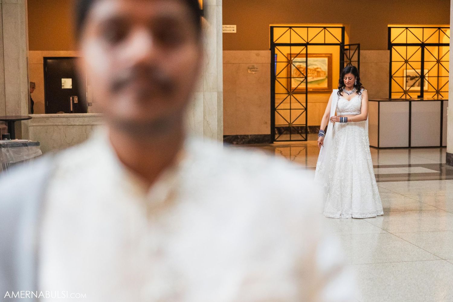 An artistic wedding photo composition with selective focus in a warmly lit indoor setting.