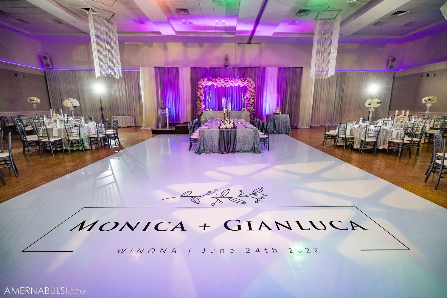 Elegant wedding reception setup with custom monogrammed dance floor and purple lighting effects.