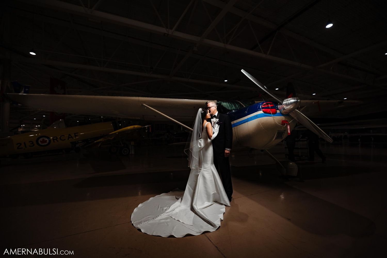 Dramatic nighttime portrait with vintage aircraft in an aviation museum hangar.