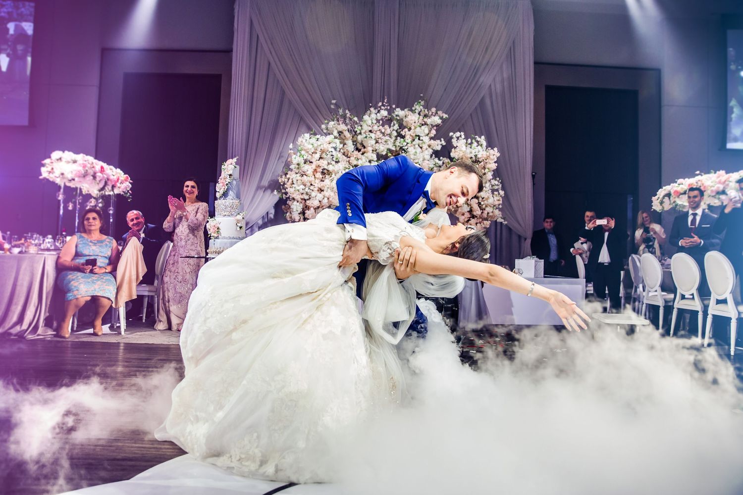 Wedding reception dance floor with decorative lighting and white draping in an elegant ballroom setting.