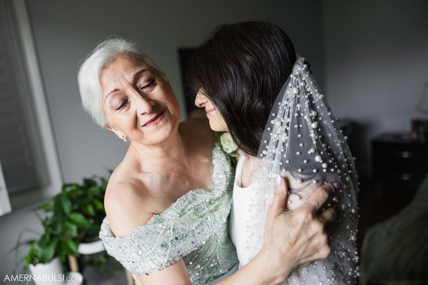 Tender moment captured between two people during wedding preparations with natural light.
