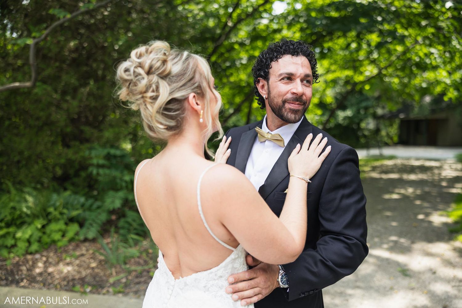 Couple shares intimate first look moment in garden setting during wedding.