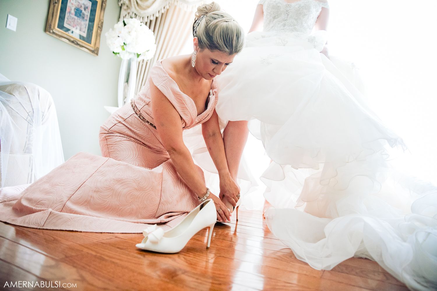 Wedding dress flowing across wooden floor in natural window light.