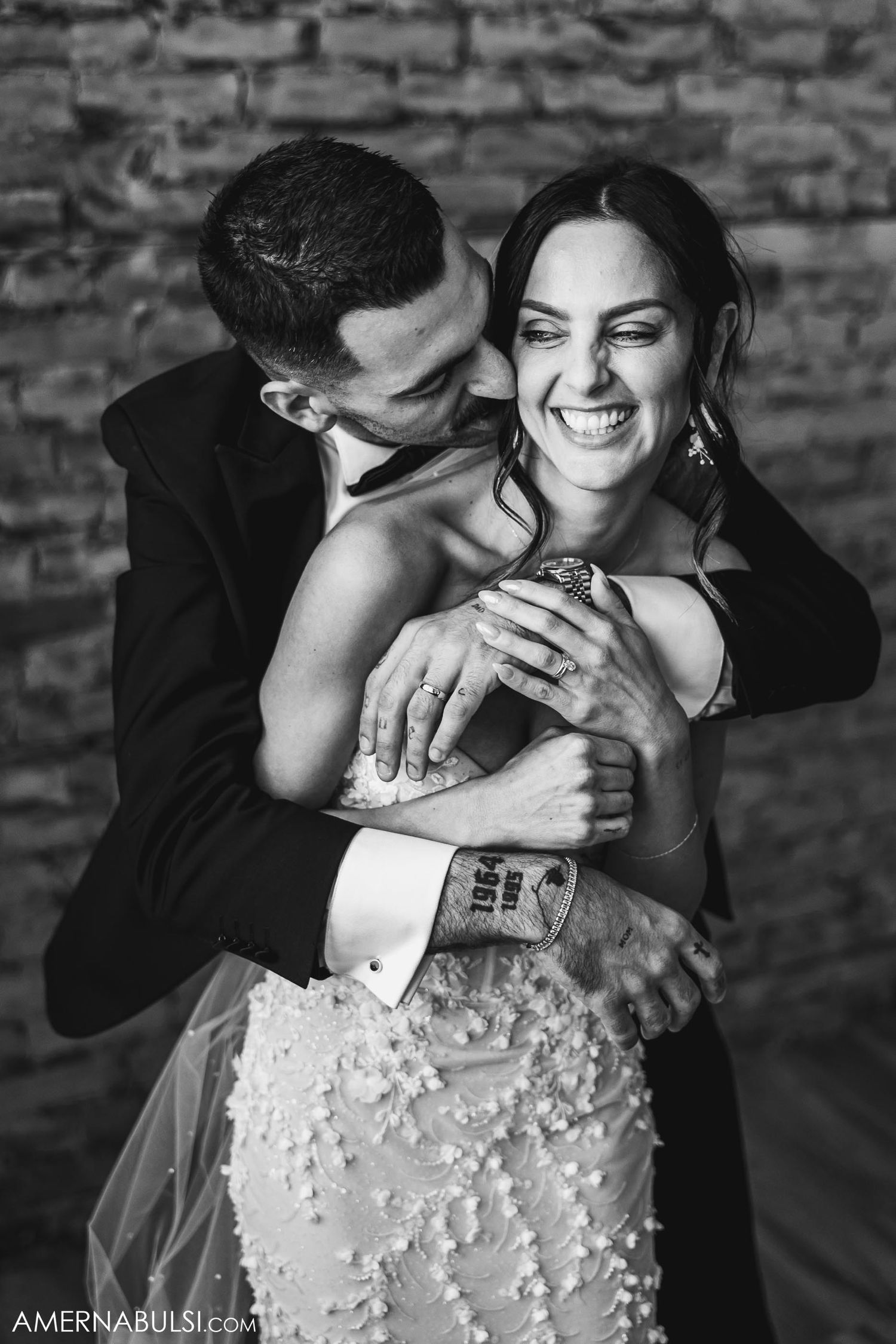 Black and white candid photo of joyful newlyweds sharing a tender moment.