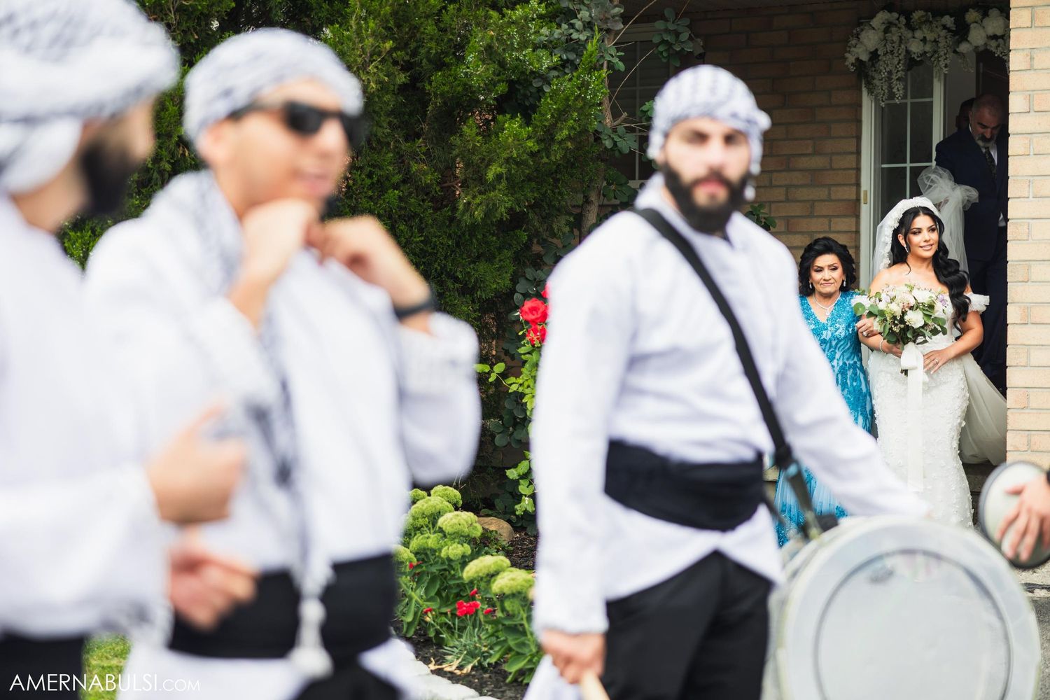 Wedding party members in white shirts gather during outdoor celebration.