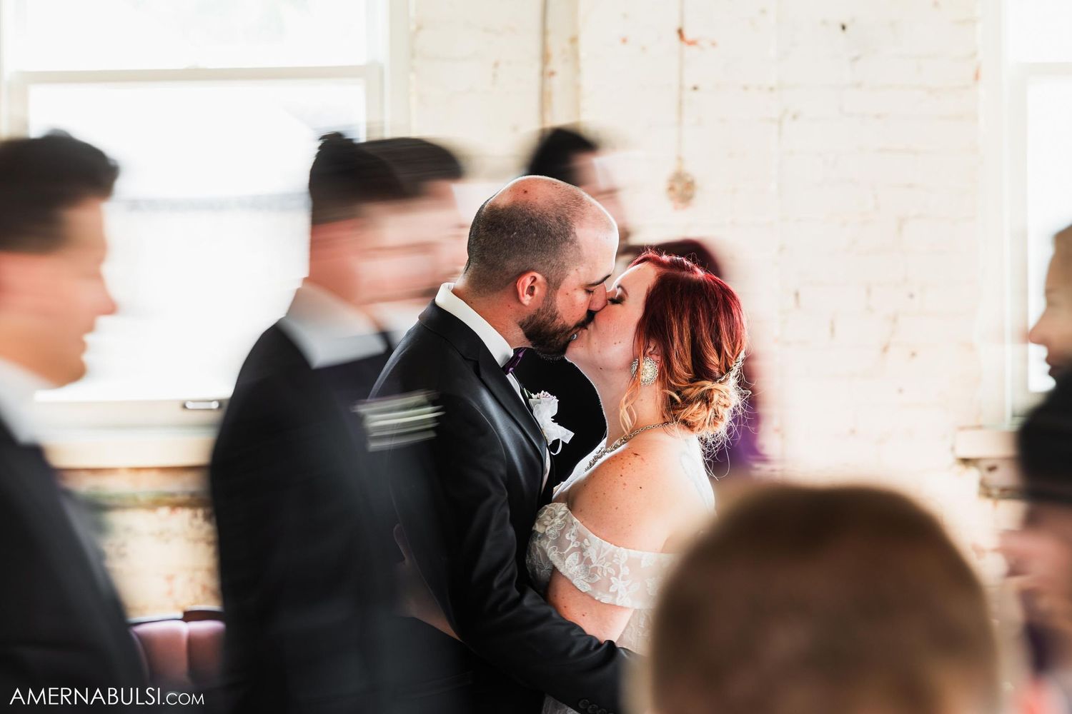 Wedding celebration moment with motion blur of guests in background.
