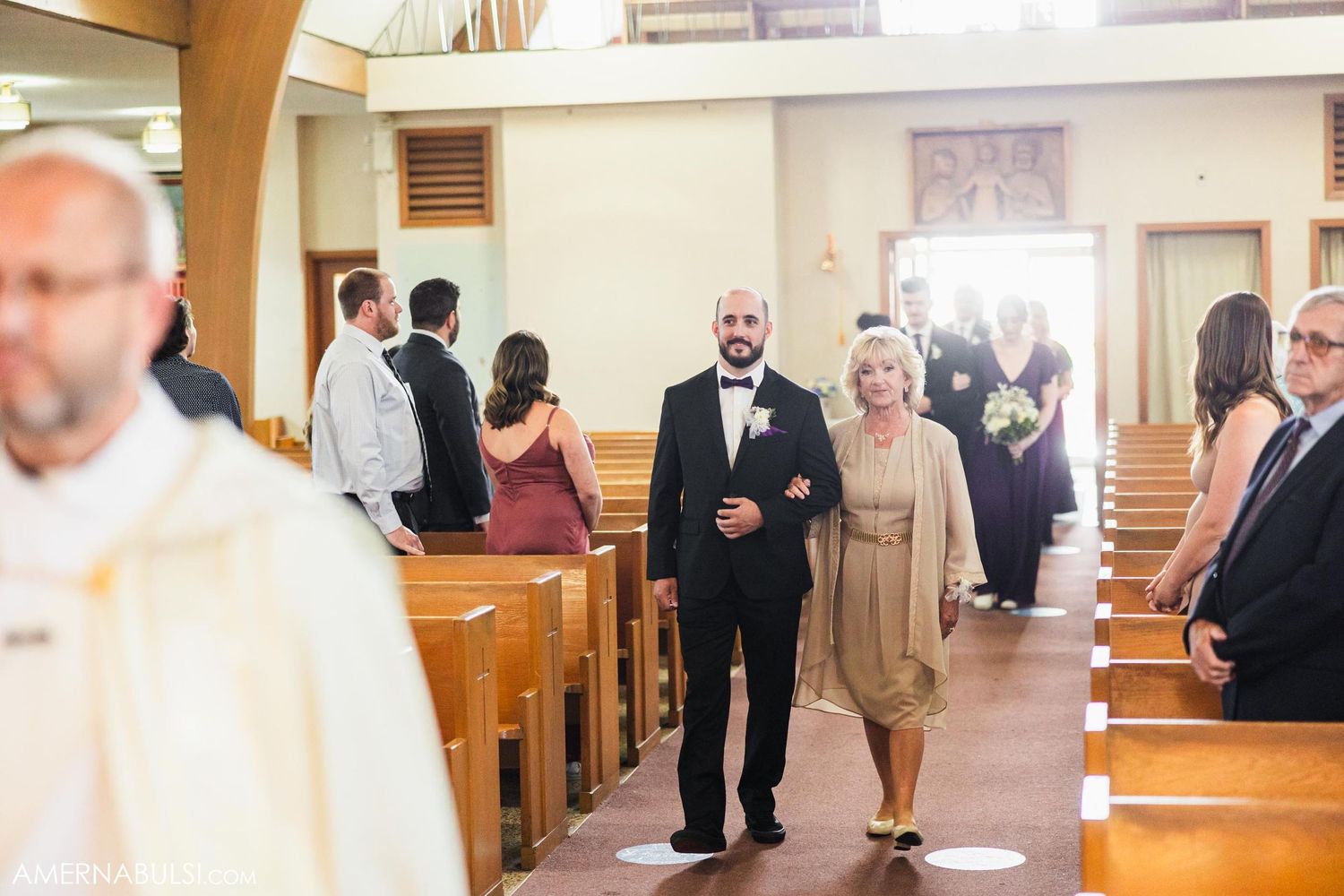 Wedding guests and attendees gather in church pews during a formal ceremony.
