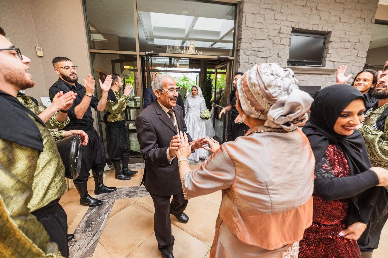 Wedding guests applauding and celebrating outside a building entrance.