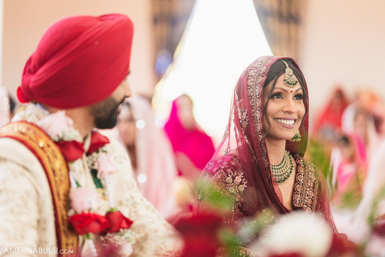 Traditional Sikh wedding couple exchanging glances during ceremony.