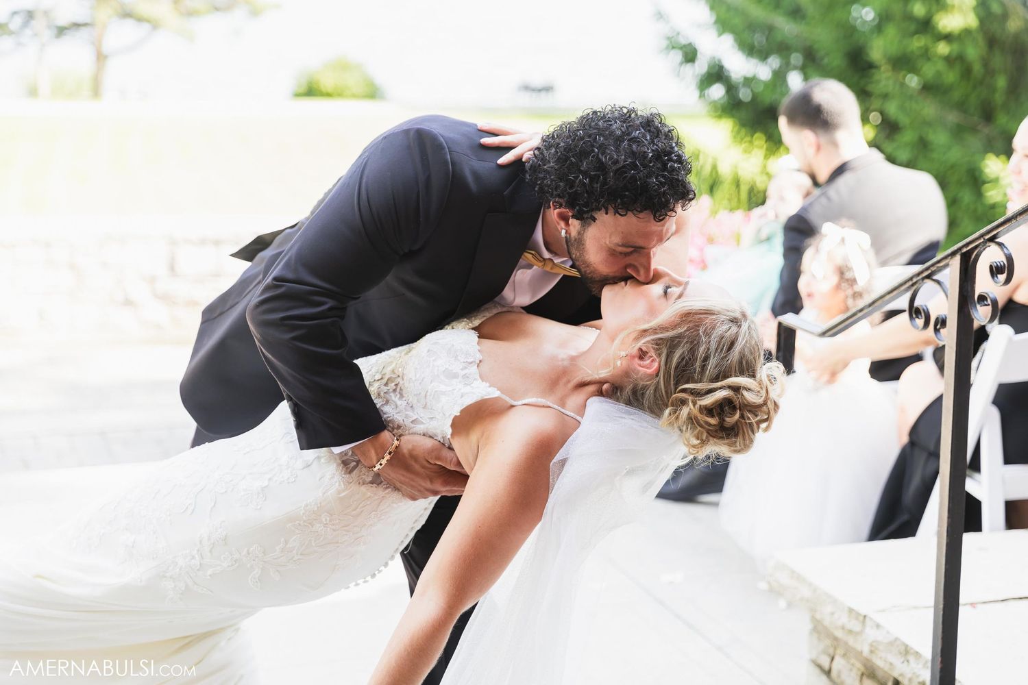 A romantic dip pose captured during outdoor wedding celebrations.