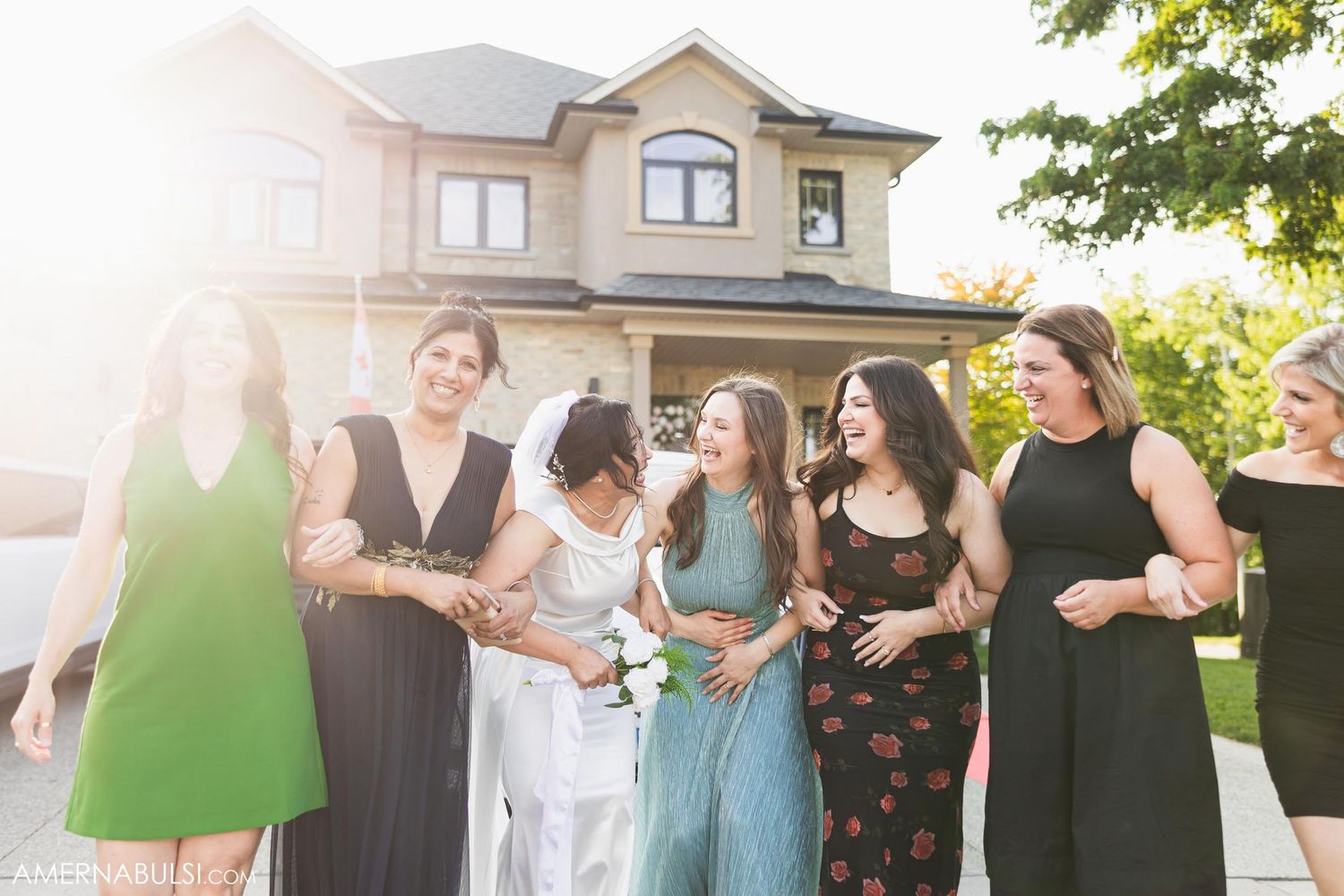 Friends sharing laughter together outdoors in front of a house.