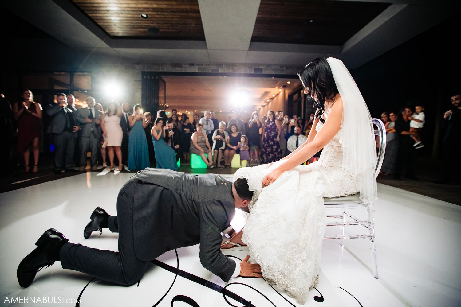 Wedding reception dance floor with dramatic lighting and guests in motion.