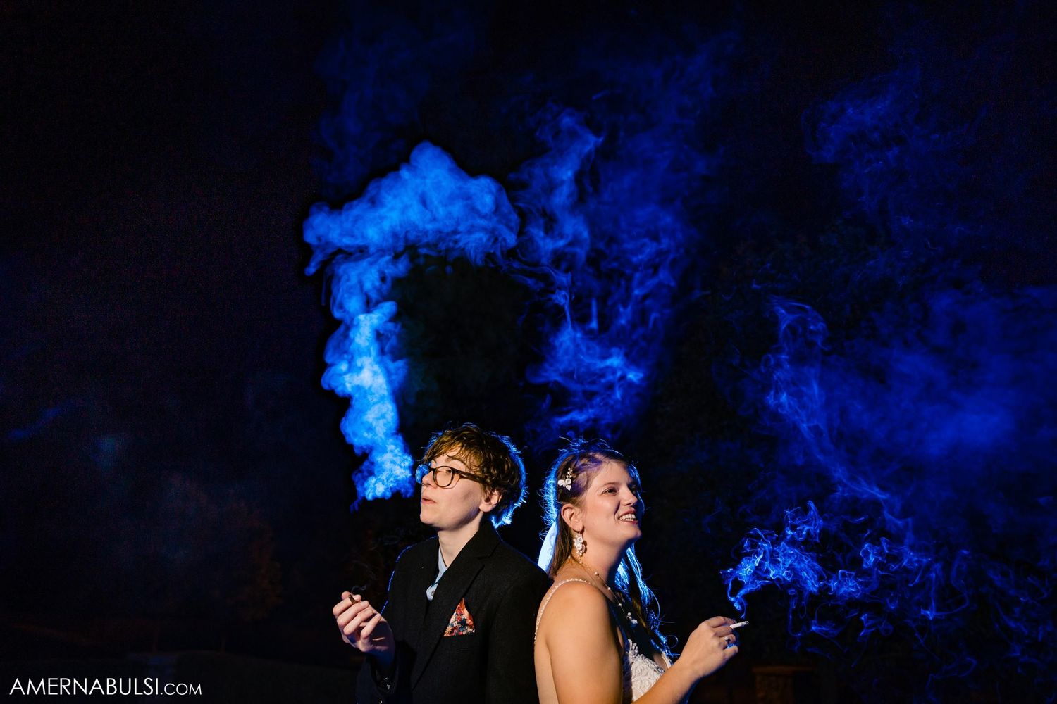 Creative portrait with blue smoke effects against dark background creating dramatic atmosphere.