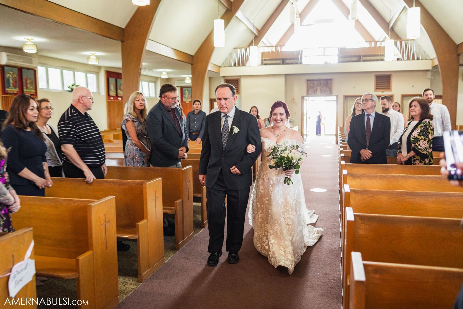 A traditional church wedding procession shows attendees gathering in wooden pews as ceremony participants walk down the aisle.