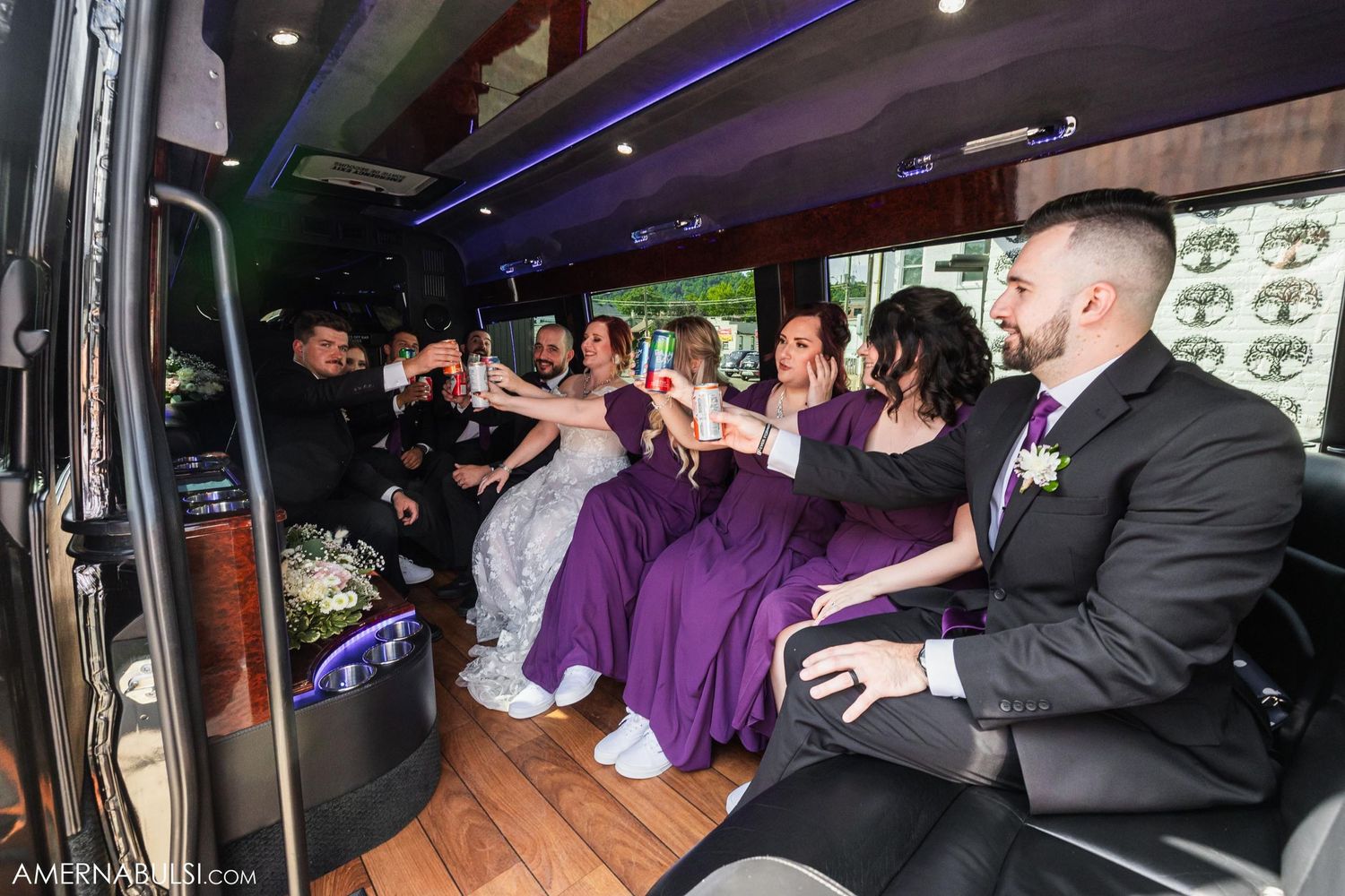Wedding party celebrating together in a decorated party bus or limousine.