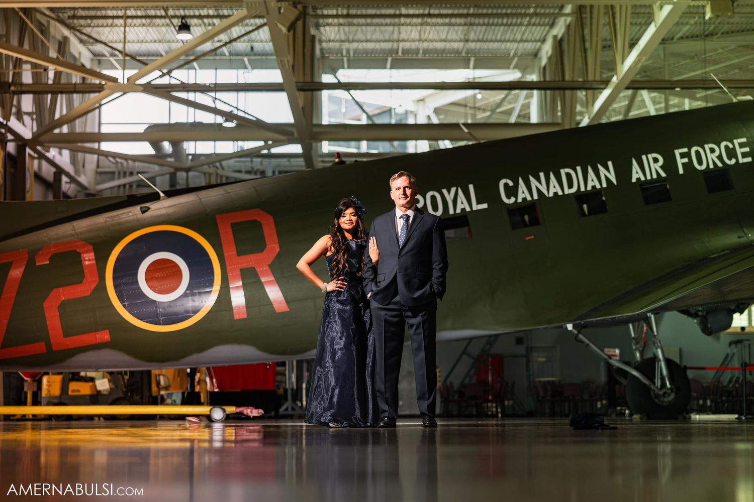 Couple standing beside Royal Canadian Air Force aircraft in museum hangar.