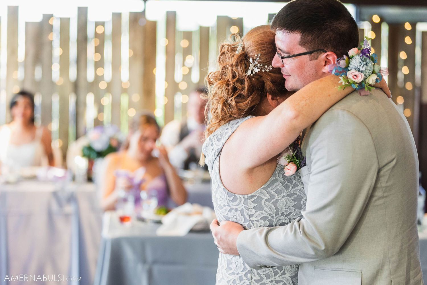 Couple shares emotional embrace during wedding reception dance.