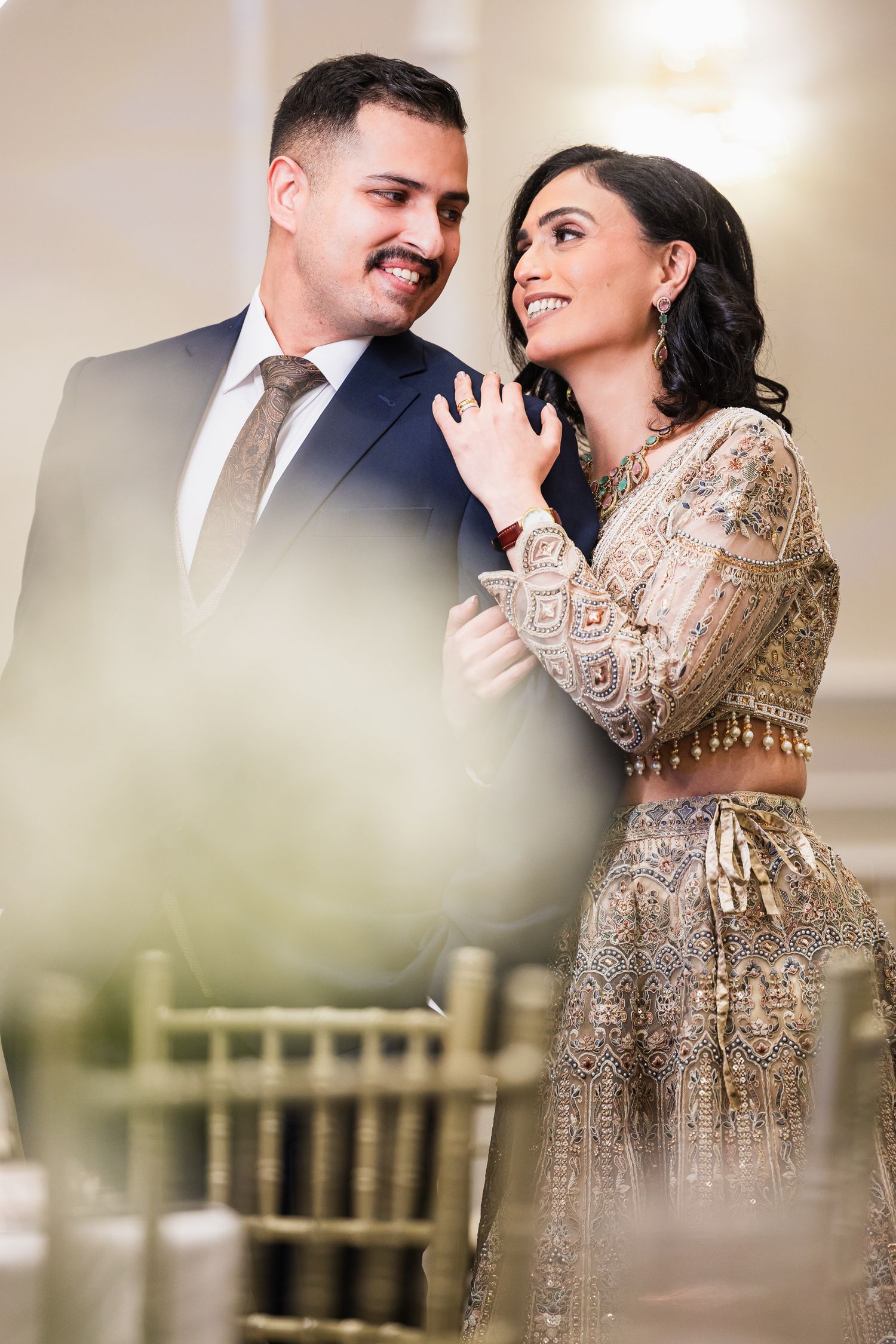 A romantic couple in formal attire share intimate moments in a series of engagement photos with soft lighting.