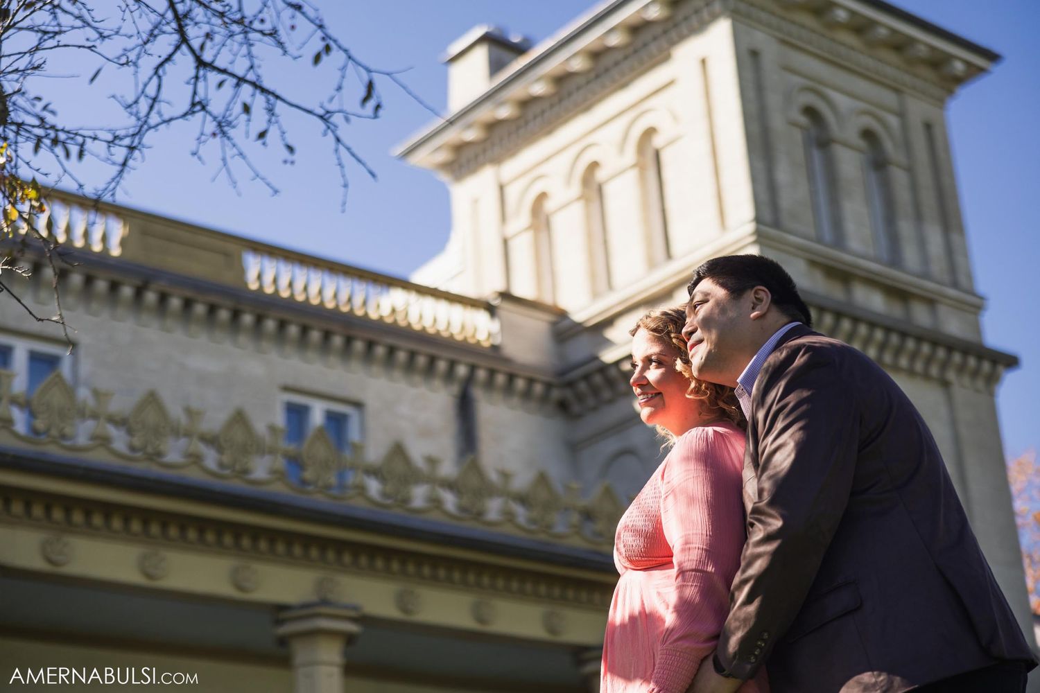 Couple standing beside ornate historic building with Italian architectural details.