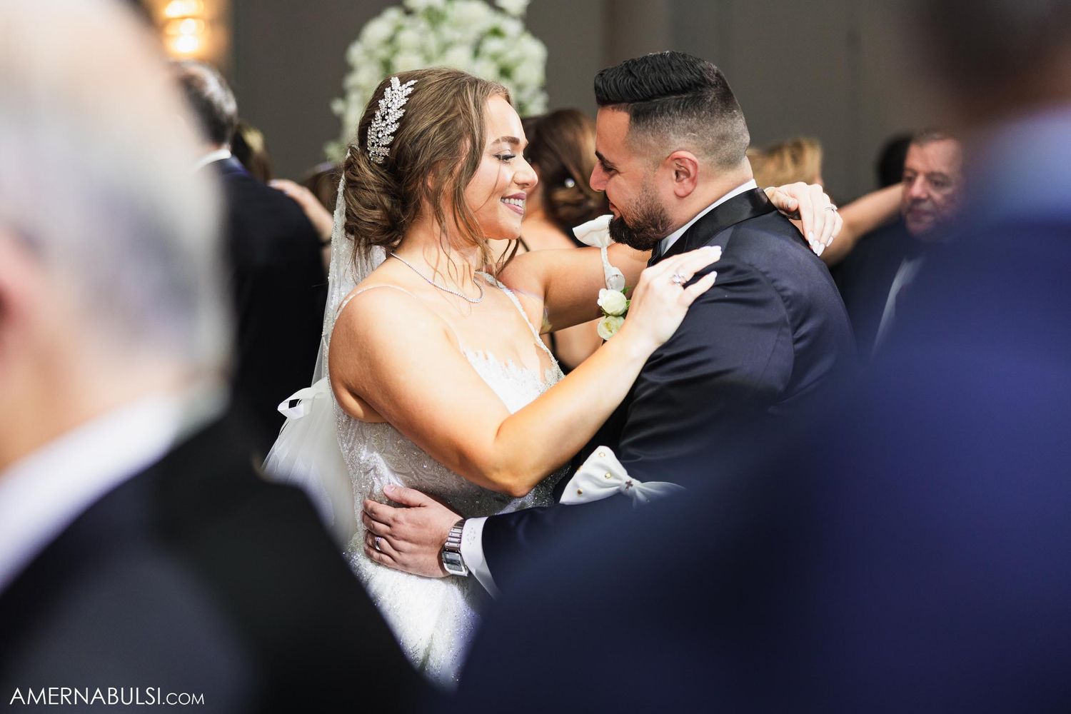 Couple shares an intimate dance moment surrounded by wedding guests.
