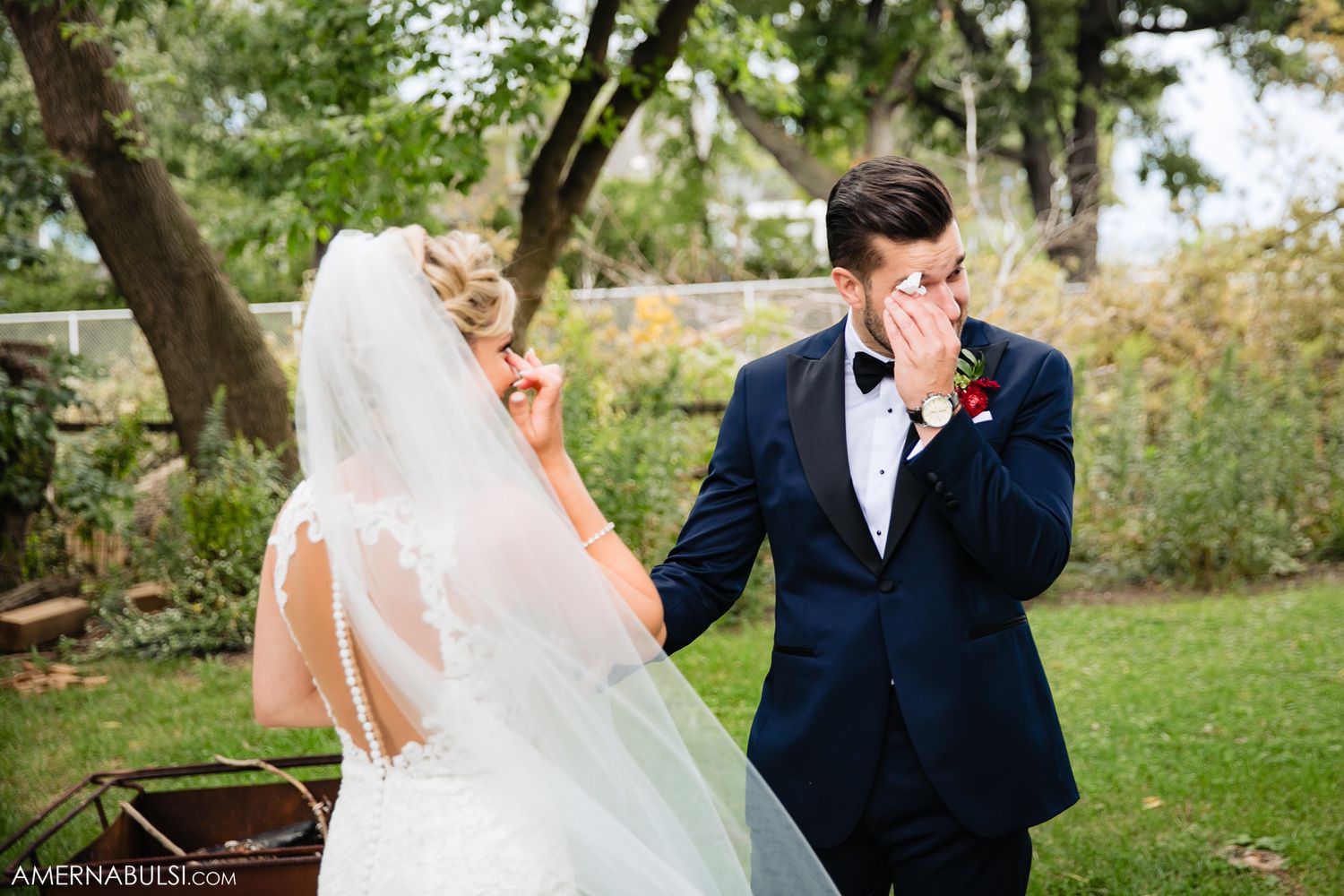 Outdoor wedding ceremony with white drapery and natural greenery backdrop.