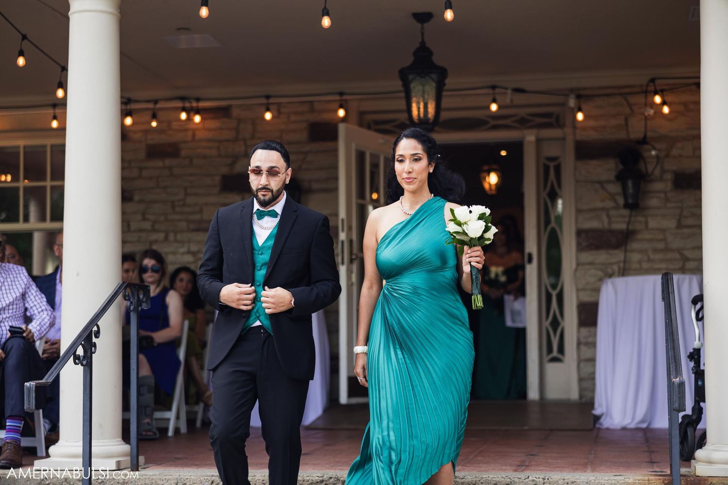 A formal procession on stone steps with a teal gown and classic black tuxedo.