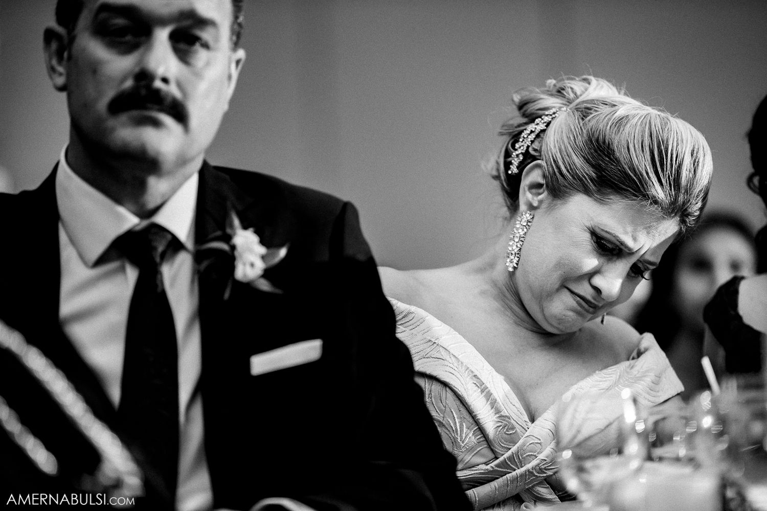 Black and white candid shots of wedding guests enjoying cocktail hour at a formal reception.