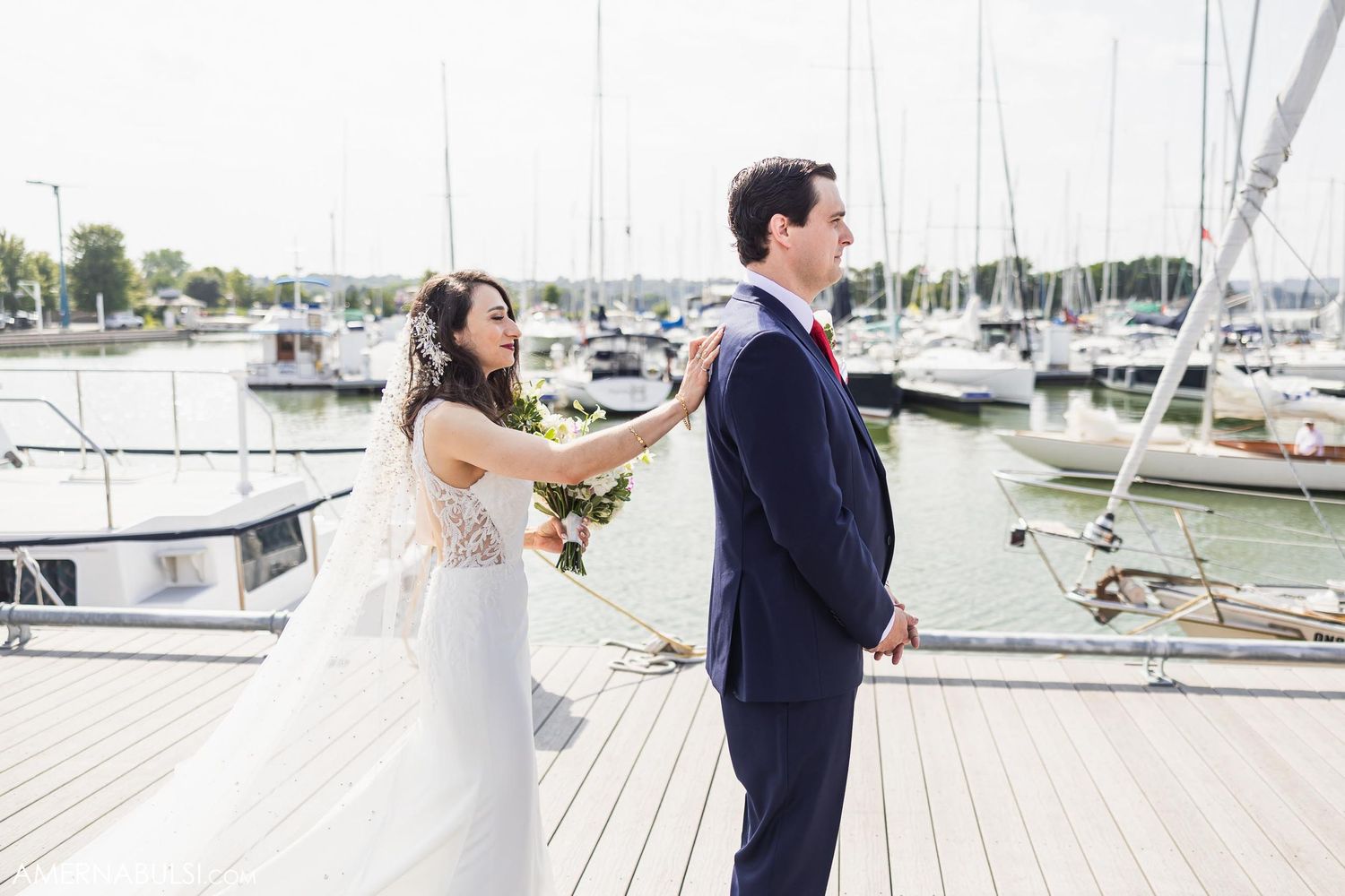 A playful wedding moment between newlyweds on a marina dock.