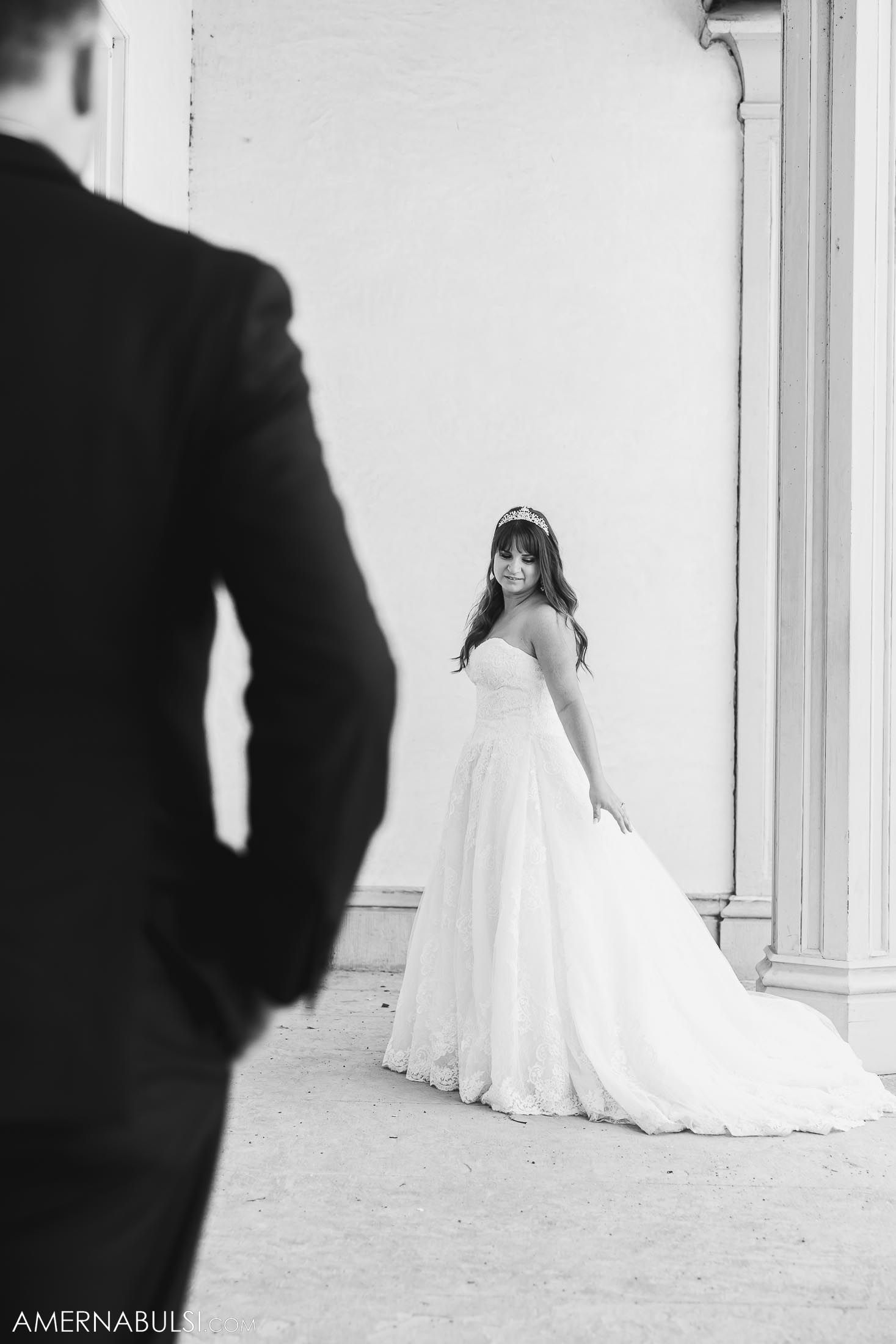 Black and white portrait of couple in wedding attire in an architectural setting.