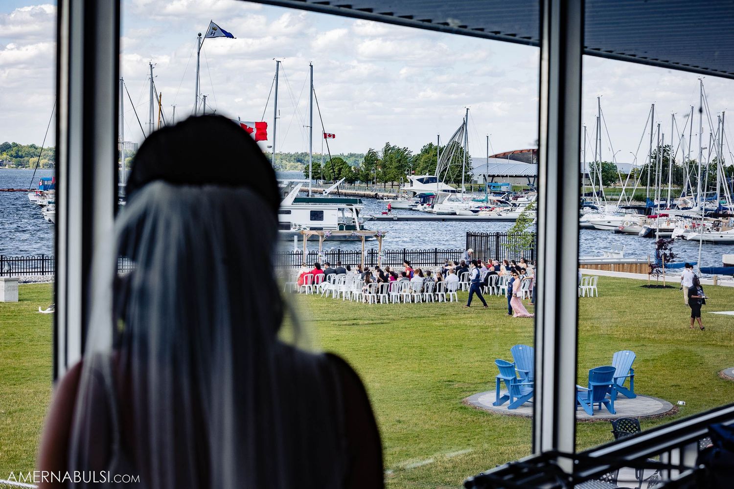 View of marina with boats and blue sky through large window.