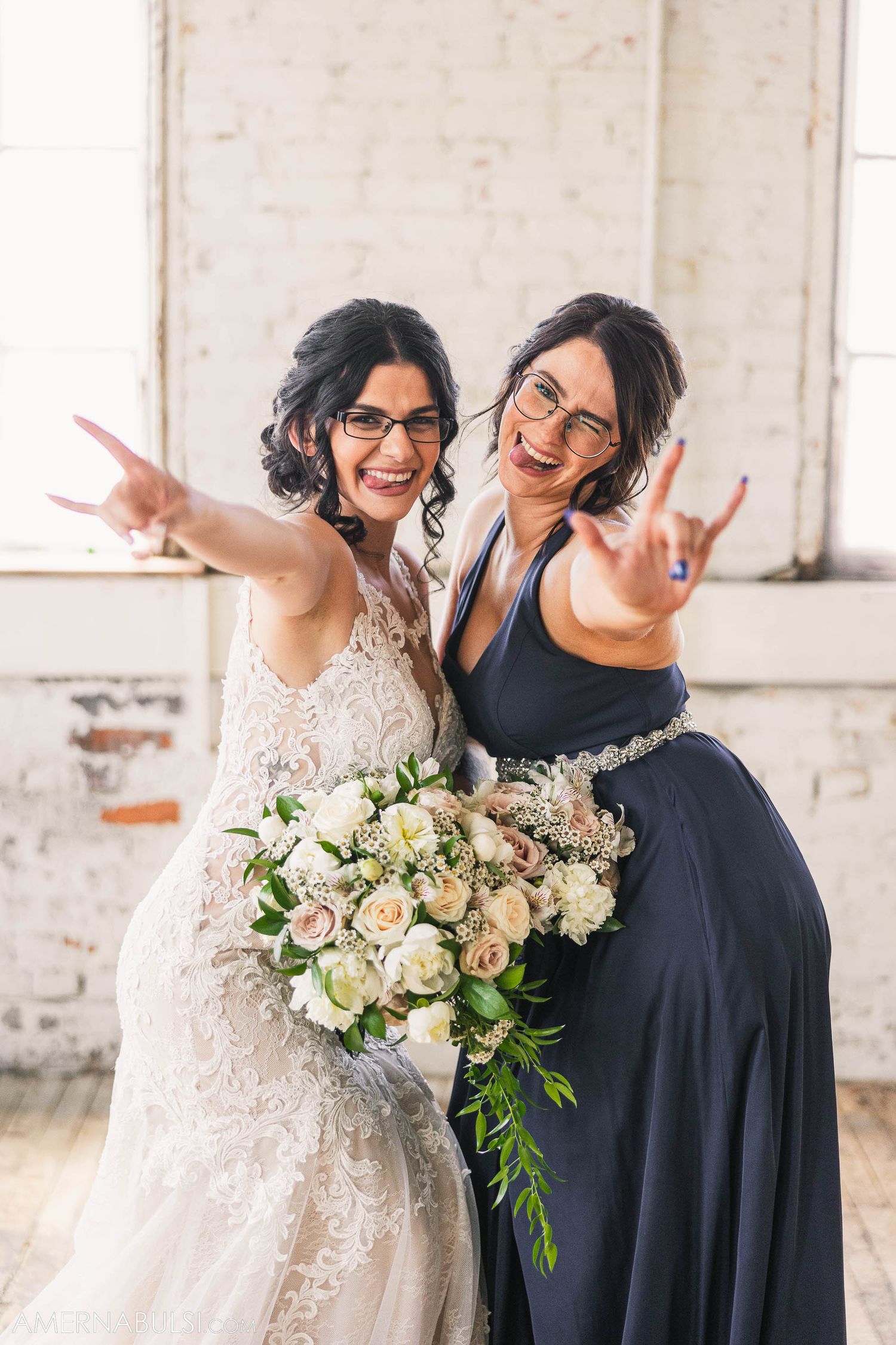 Two figures pose energetically in formal attire with white floral bouquet.