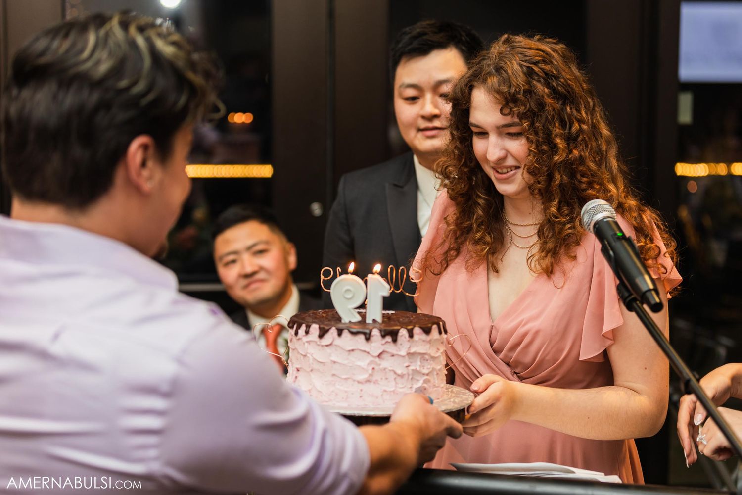 A cake cutting moment at an elegant wedding reception with guests watching.