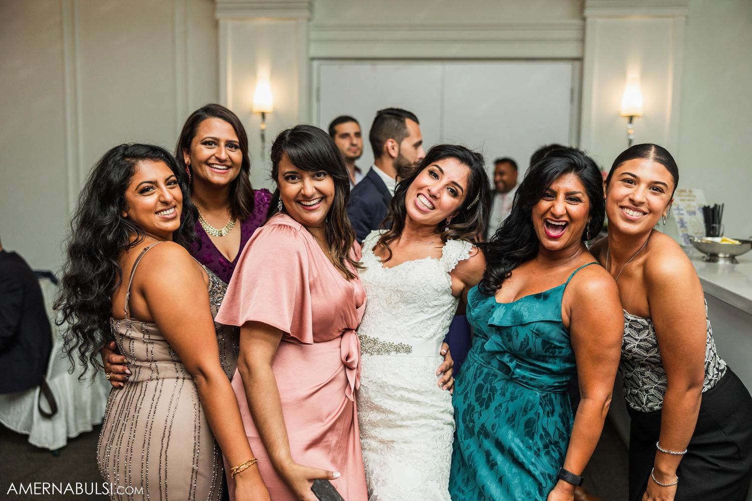 A group celebrating at a wedding reception in formal attire.