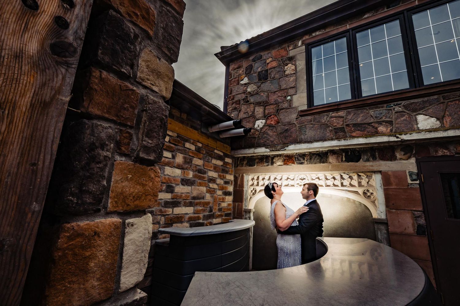 Romantic scene of a couple in rustic brick room with dramatic lighting.
