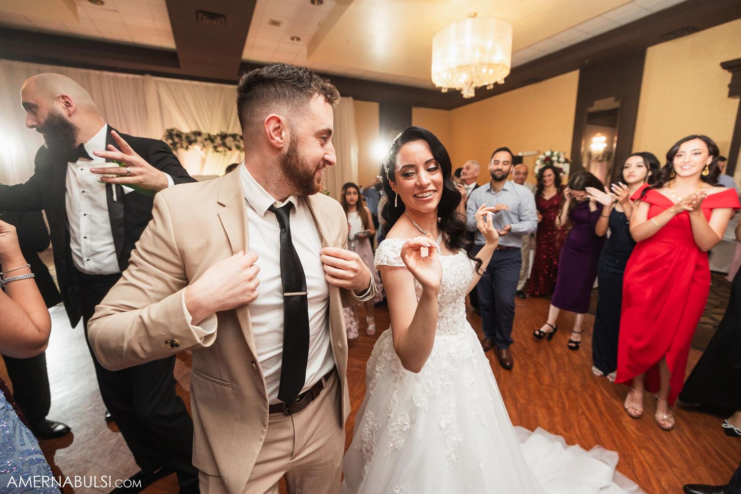 Bride and wedding guest dancing energetically during reception celebration.