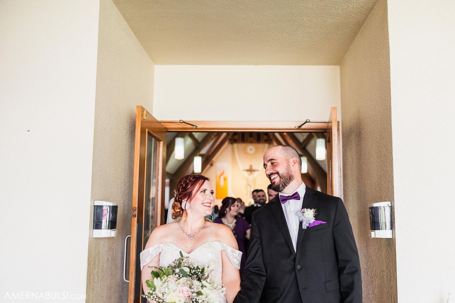 Wedding couple shares an intimate moment in a doorway of their ceremony venue.